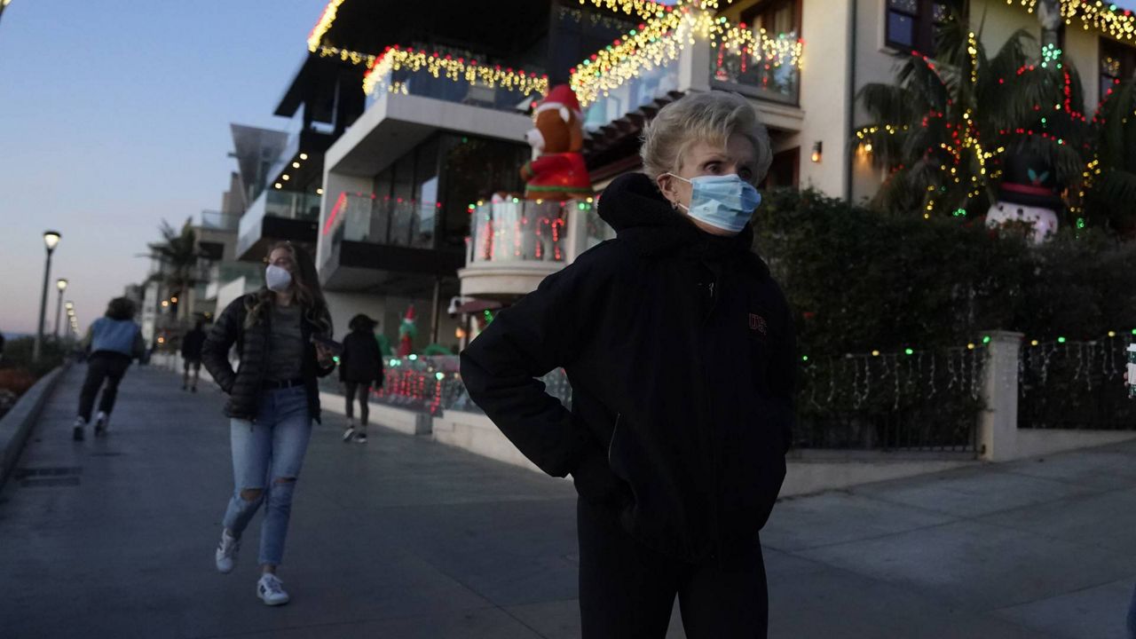 People wear face masks as they use a paved path along the beach amid the pandemic Dec. 14, 2020, on Manhattan Beach in L.A. (AP/Marcio Jose Sanchez)