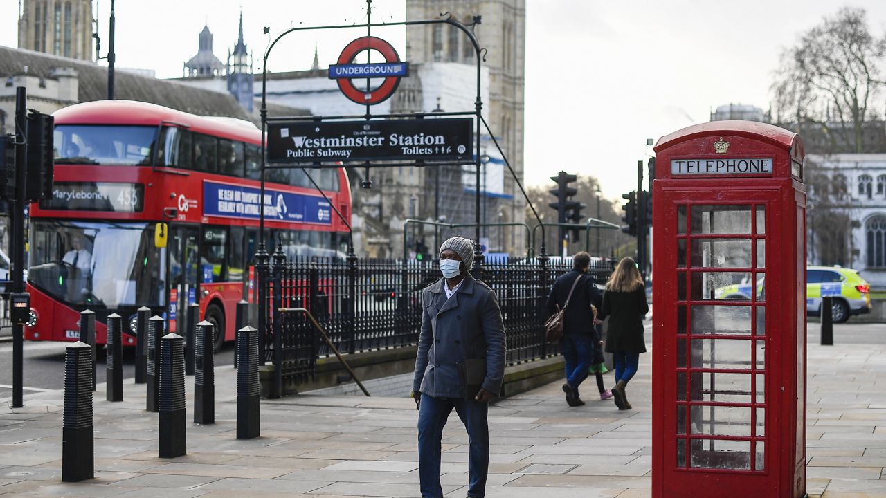 A man wears a face mask to protect from coronavirus as he walks past Westminster underground station, in London, Tuesday, Dec. 15, 2020. (AP Photo/Alberto Pezzali)