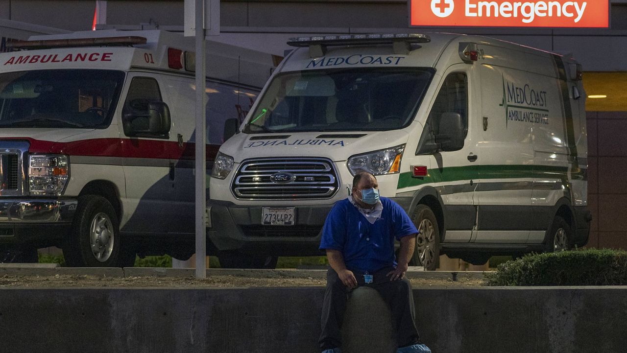 Darren Arthur, an environmental services worker, takes a break outside the Los Angeles County+USC Medical Center emergency ramp in Los Angeles, late Wednesday, Dec. 16, 2020. (AP Photo/Damian Dovarganes)