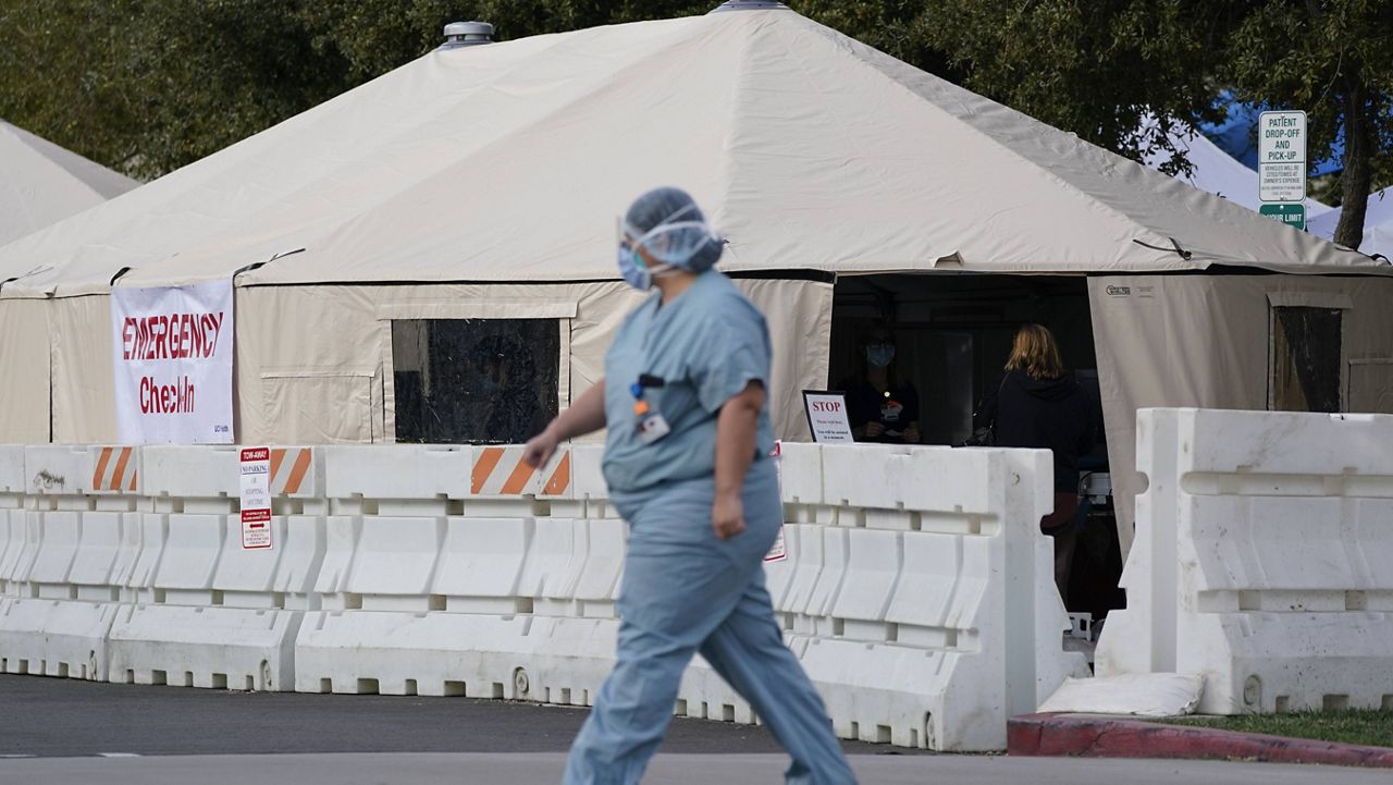A medical worker passes a medical tent outside the emergency room at UCI Medical Center Thursday, Dec 17, 2020, in Irvine, Calif. (AP Photo/Ashley Landis)