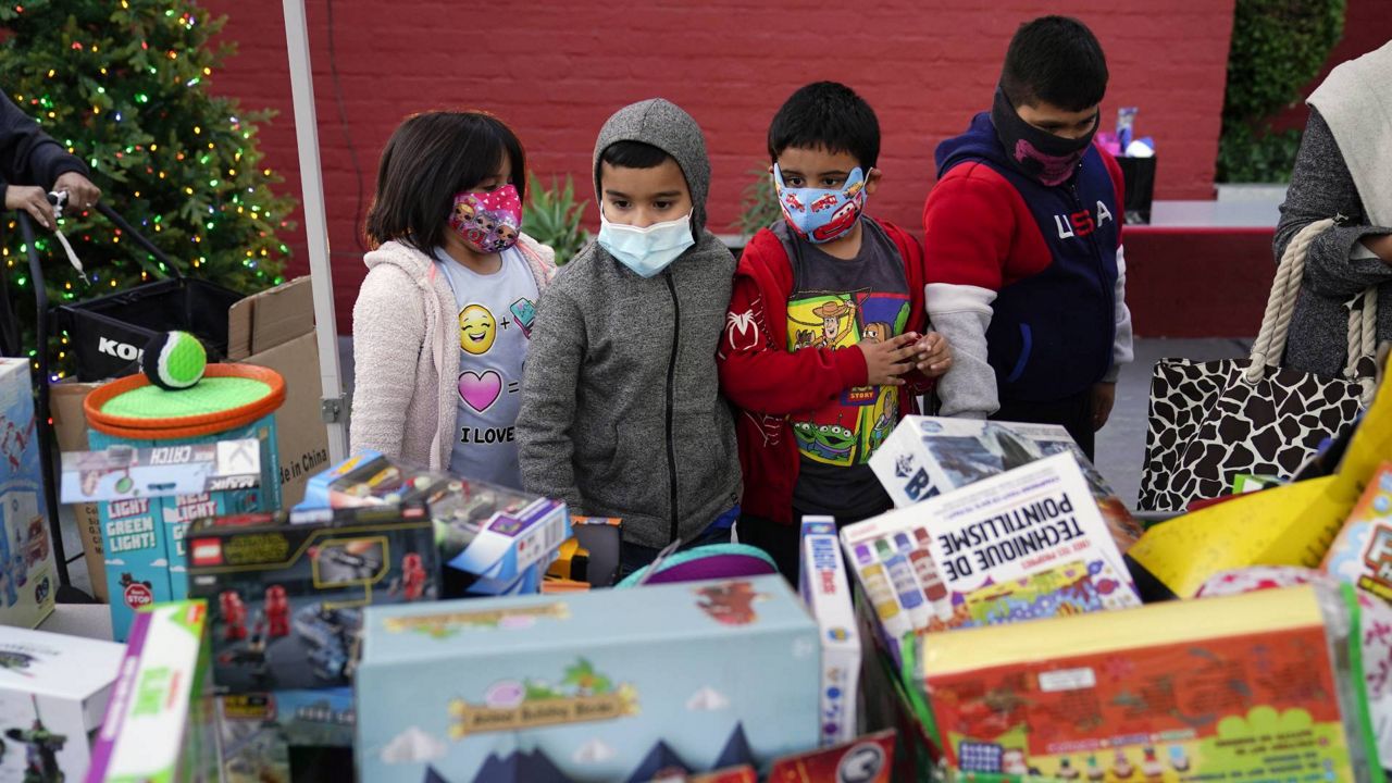 Children choose their toys at a holiday toy giveaway held at Los Angeles Boys & Girls Club in the Lincoln Heights neighborhood of LA on Dec. 17, 2020. (AP Photo/Jae C. Hong)