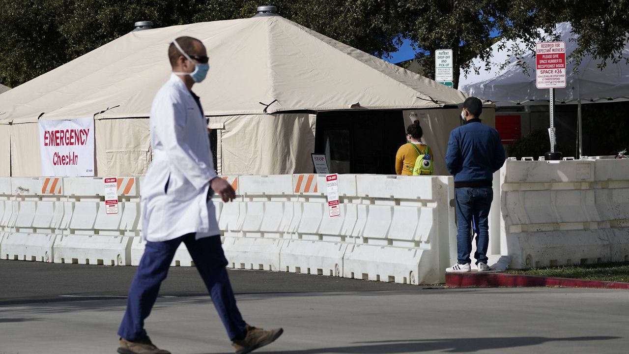 In this Dec. 17, 2020, file photo, a medical worker passes a medical tent outside the emergency room at UCI Medical Center in Irvine, Calif. (AP Photo/Ashley Landis, File)