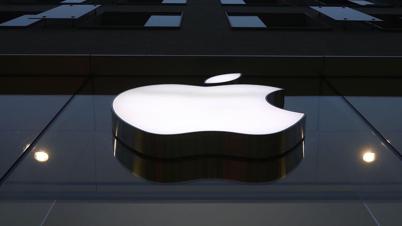 The logo of Apple is illuminated at a store in the city center in Munich, Germany, Wednesday, Dec. 16, 2020. (AP Photo/Matthias Schrader)