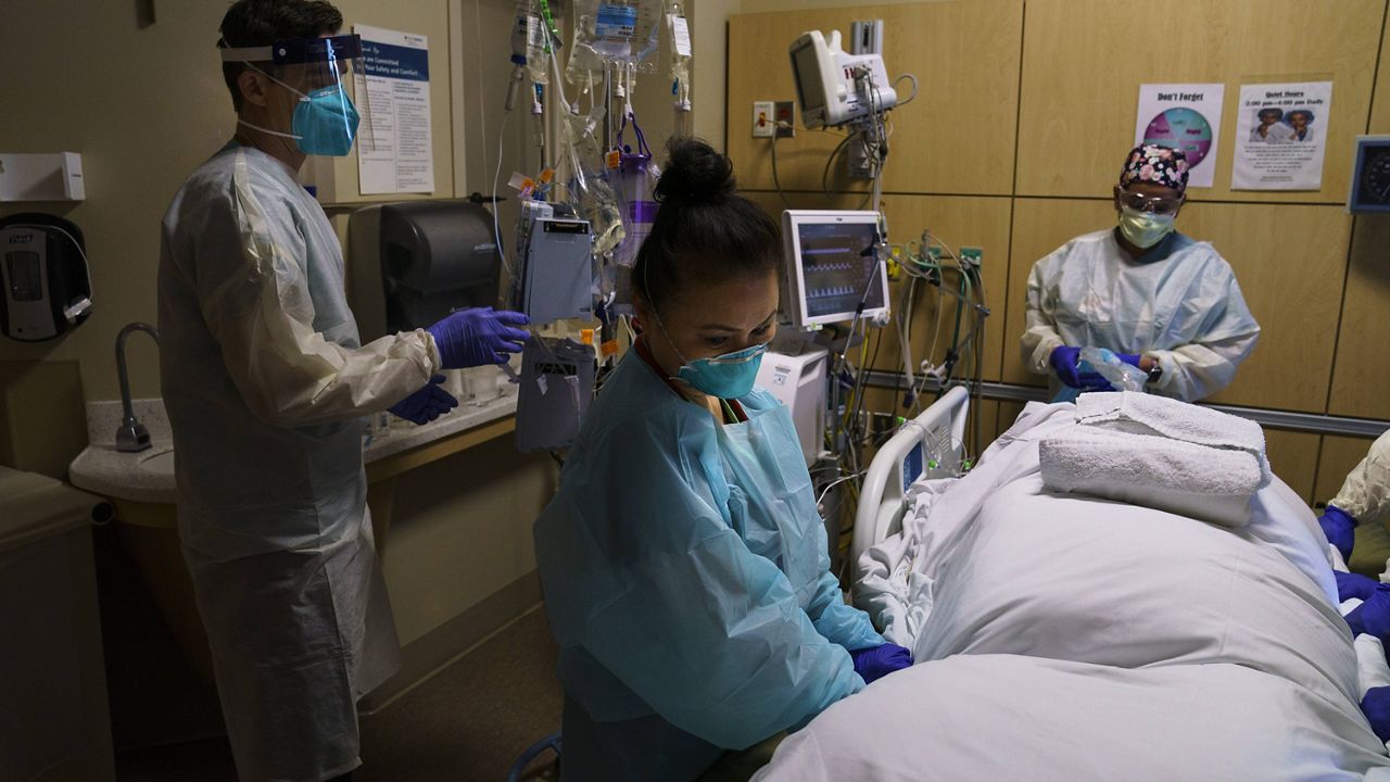 Nurses prepare to prone a COVID-19 patient at Providence Holy Cross Medical Center in the Mission Hills section of Los Angeles, Thursday, Nov. 19, 2020. (AP Photo/Jae C. Hong)