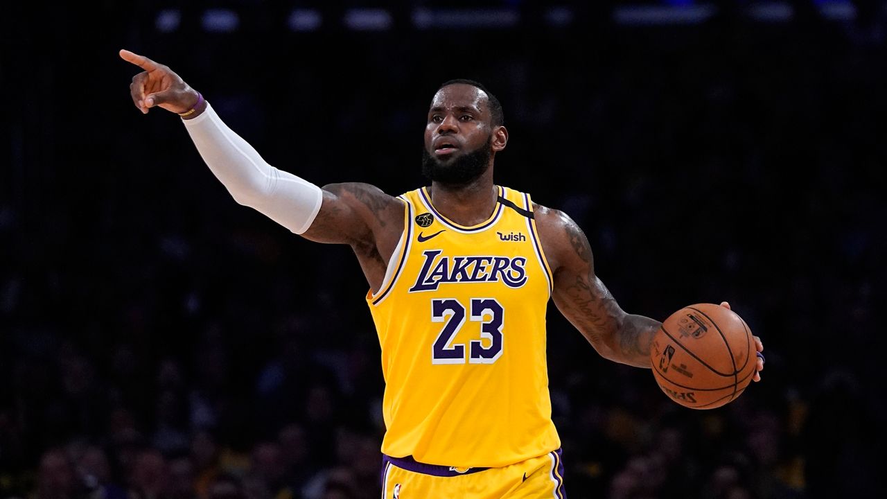 In this March 6, 2020, file photo, Los Angeles Lakers forward LeBron James gestures to teammates during the second half of an NBA basketball game against the Milwaukee Bucks in Los Angeles. (AP Photo/Mark J. Terrill, File)