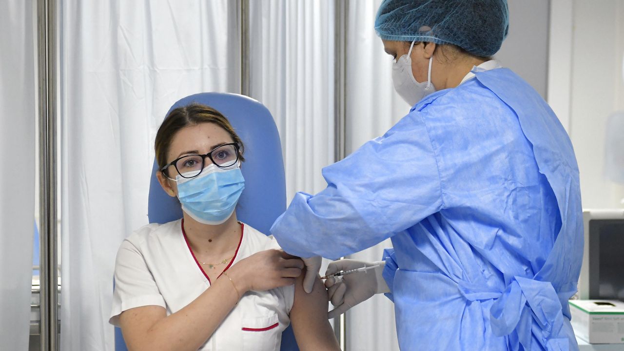 Mihaela Anghel, a Romanian nurse, gets the first COVID-19 vaccine administered in the country in Bucharest, Romania, Sunday, Dec. 27, 2020. Anghel is the nurse who registered and processed Romania's first official COVID-19 patient, on Feb. 27, 2020.