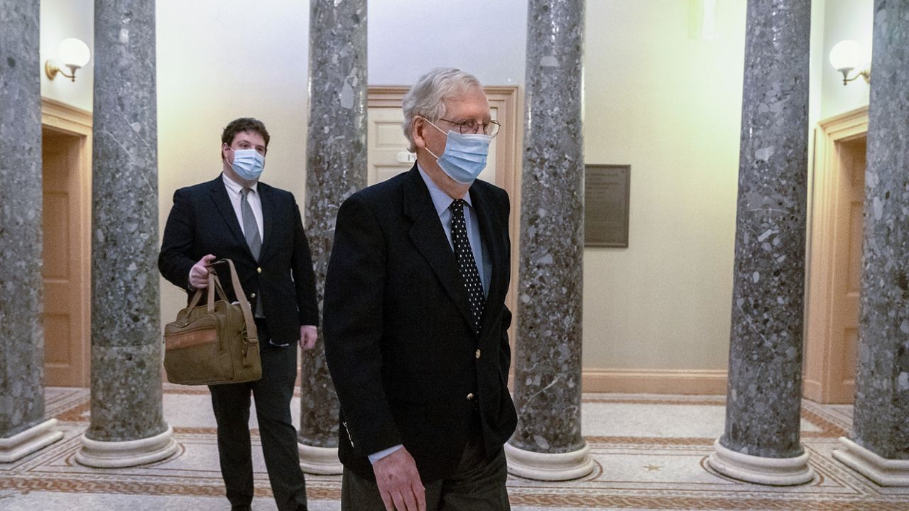 Followed by a staffer with a bag, Senate Majority Leader Mitch McConnell of Ky., right, leaves the Capitol for the day, Tuesday, Dec. 29, 2020, on Capitol Hill in Washington. (AP Photo/Jacquelyn Martin)