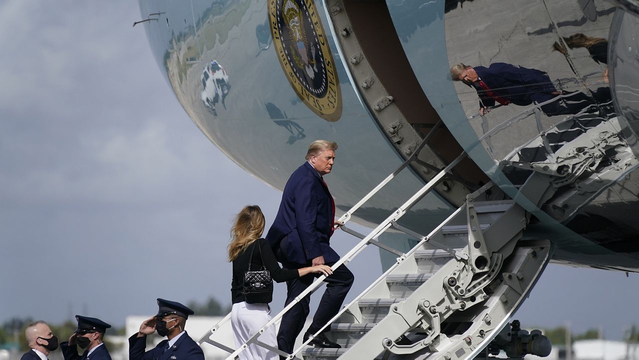 President Donald Trump and first lady Melania Trump board Air Force One at Palm Beach International Airport, Thursday, Dec. 31, 2020, in West Palm Beach, Fla. (AP Photo/Patrick Semansky)