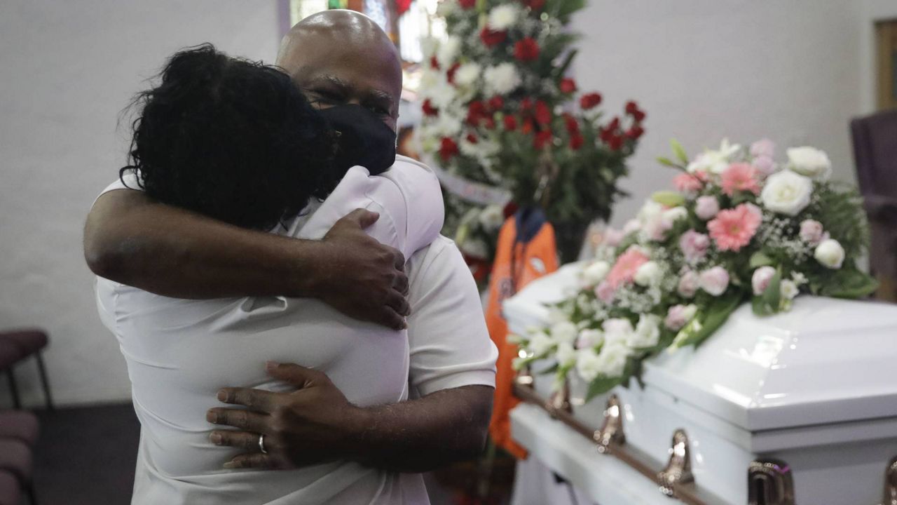 In this July 21, 2020 file photo, Darryl Hutchinson, facing camera, is hugged by a relative during a funeral service at the Metropolitan Baptist Church in L.A. (AP/Marcio Jose Sanchez)