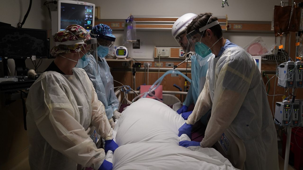 FILE - In this Dec. 22, 2020, file photo, medical workers prepare to manually prone a COVID-19 patient in an intensive care unit at Providence Holy Cross Medical Center in the Mission Hills section of Los Angeles. (AP Photo/Jae C. Hong, File)