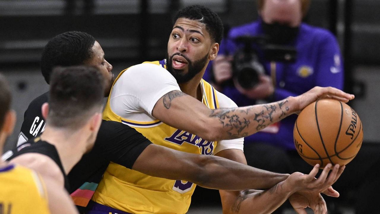 Anthony Davis, right, keeps the ball from San Antonio Spurs' Rudy Gay, left rear, and Drew Eubanks during an NBA game Friday, Jan. 1, 2021, in San Antonio. (AP/Darren Abate)