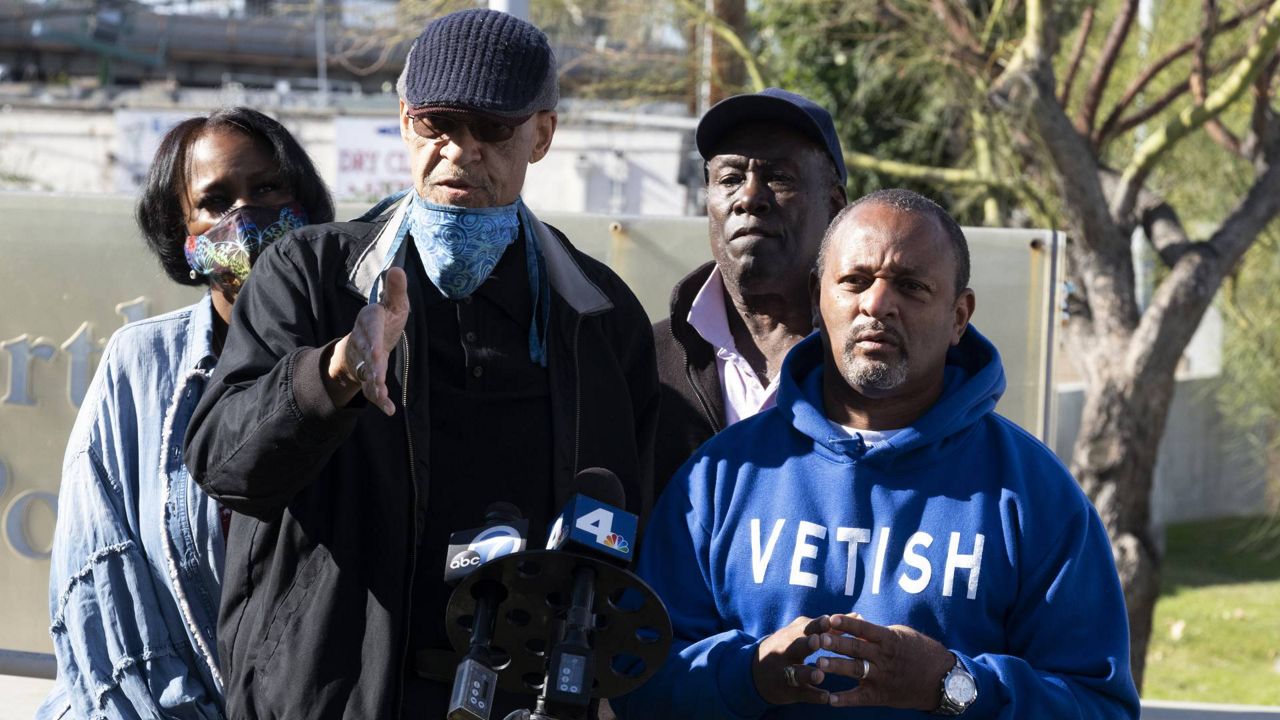 Civil rights activists Najee Ali, right and L.A. Urban Policy Roundtable President Earl Ofari Hutchinson address the media in front of the North Hollywood Police station on Saturday, Jan. 2, 2021. (AP/Richard Vogel)