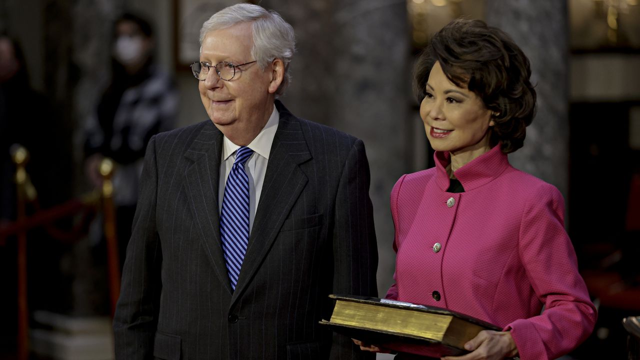 Transportation Secretary Elaine Chao waits for her husband, Senate Majority Leader Mitch McConnell, to be sworn in during a reenactment ceremony in the Old Senate Chamber at the Capitol in Washington, Sunday, Jan. 3, 2021. (Samuel Corum/Pool via AP)