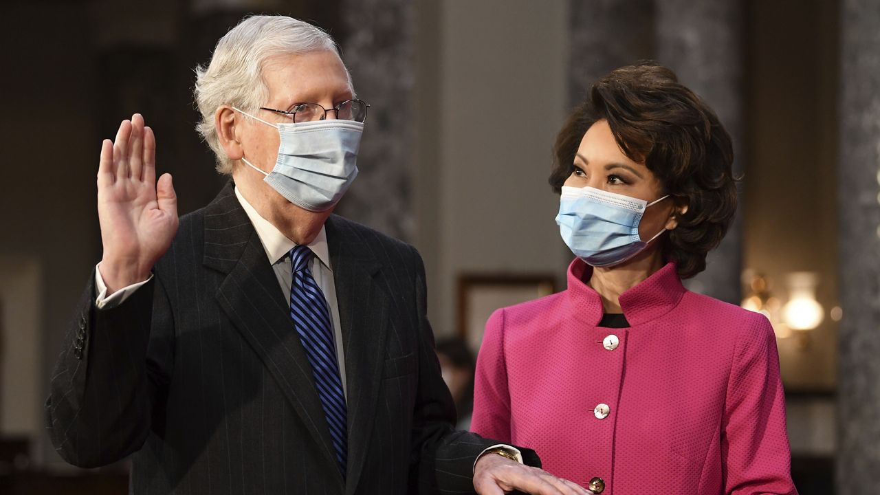 Sen. Mitch McConnell, R-Ky., participates in a mock swearing-in as his wife Transportation Secretary Elaine Chao holds a Bible, in the Old Senate Chamber at the Capitol in Washington, Sunday, Jan. 3, 2021. (Kevin Dietsch/Pool via AP)