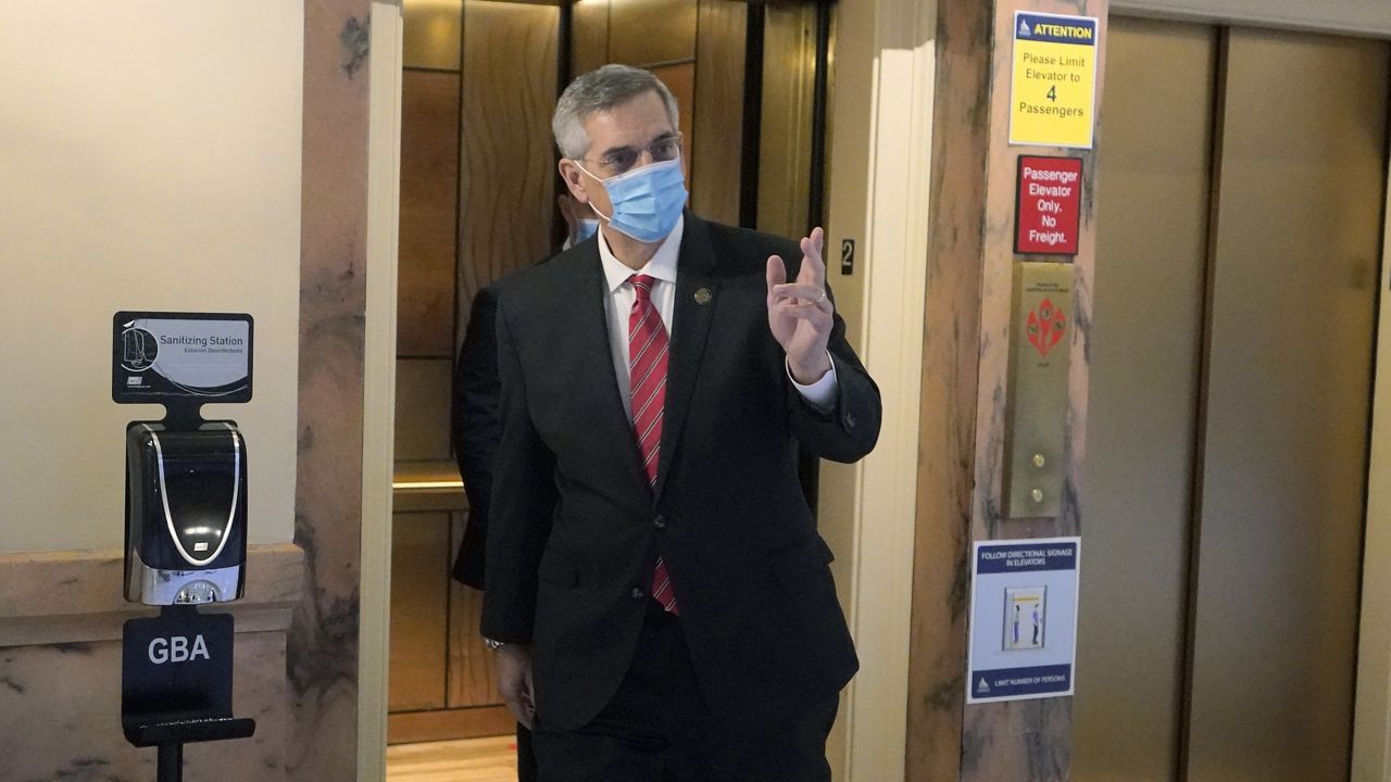 Georgia Secretary of State Brad Raffensperger waves to photographers as he walks to his office in the Capitol Building Monday, Jan. 4, 2021, in Atlanta. (AP Photo/John Bazemore)