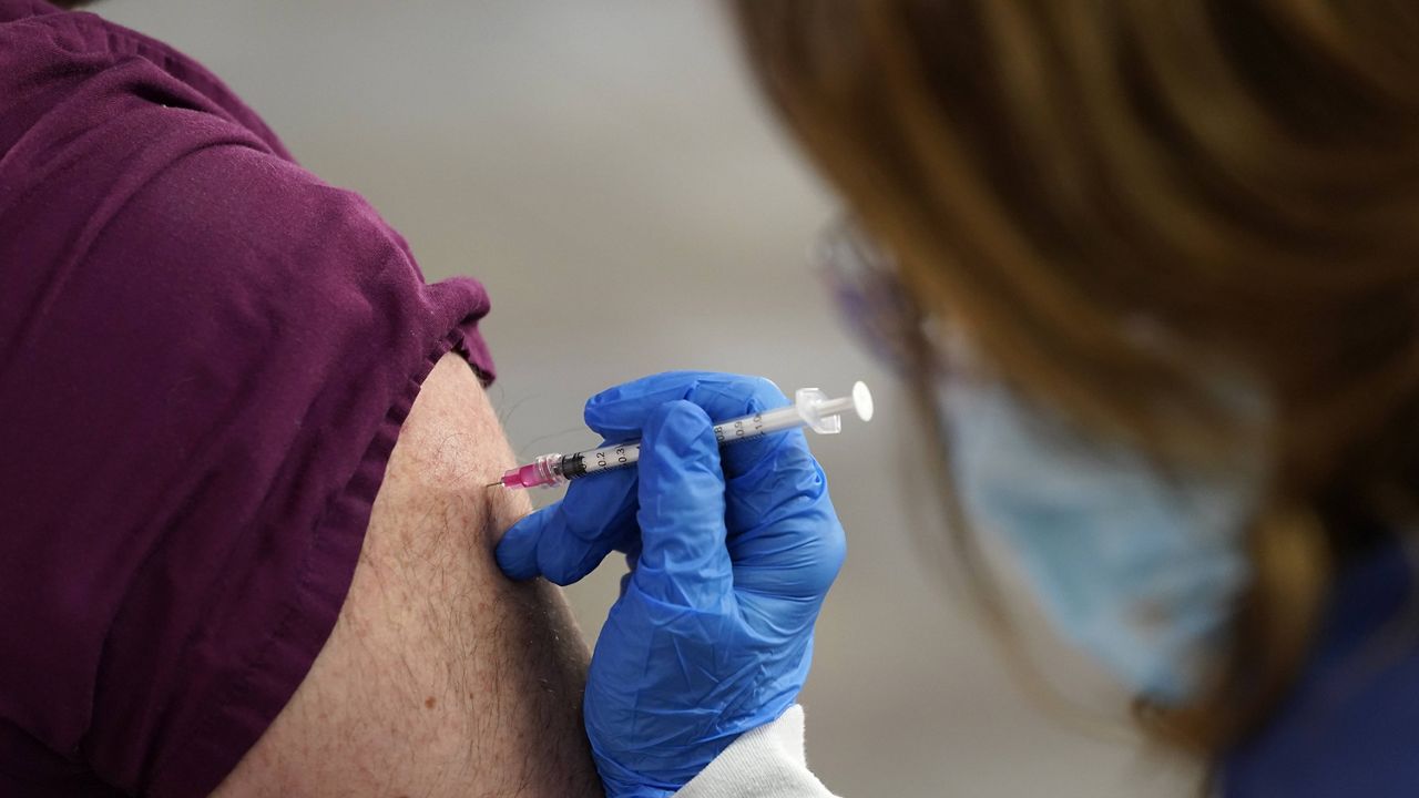 A health care worker receives a Pfizer-BioNTech COVID-19 vaccine shot at Beaumont Health in Southfield, Mich. (AP Photo/Paul Sancya, File)