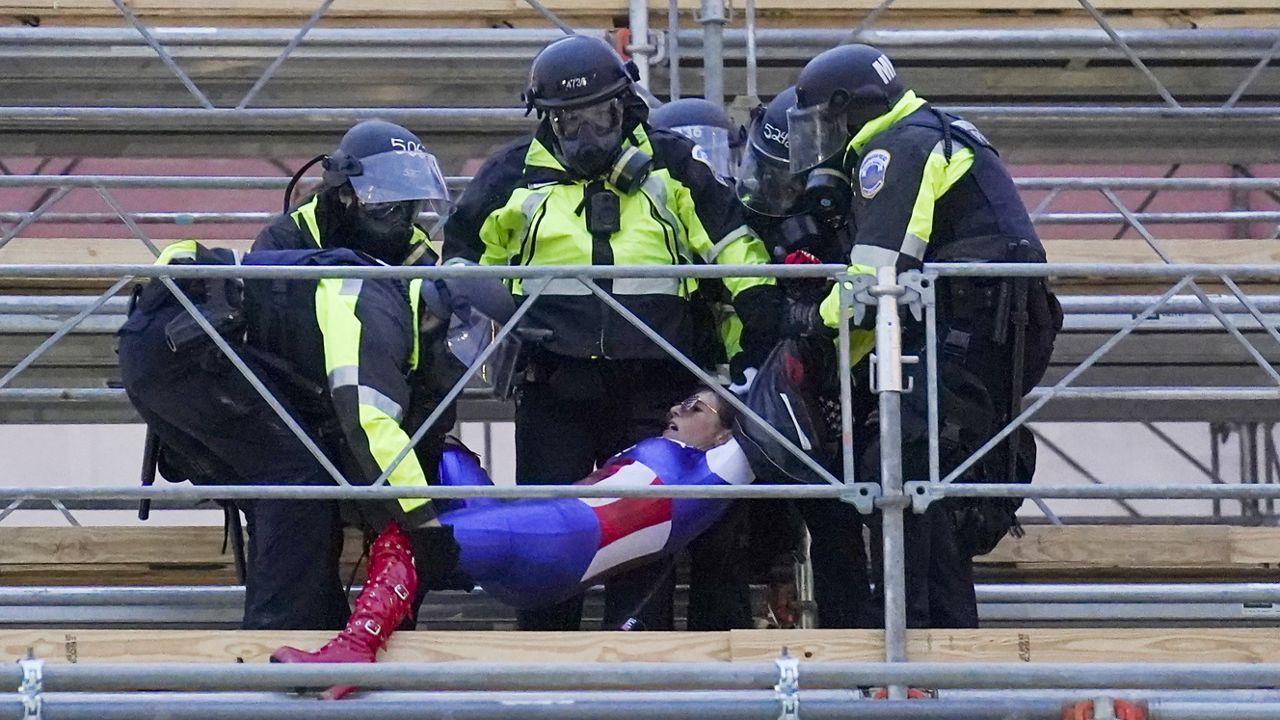 A demonstator loyal to President Donald Trump, is removed by police, Wednesday, Jan. 6, 2021, during a day of rioting at the Capitol. (AP Photo/John Minchillo)