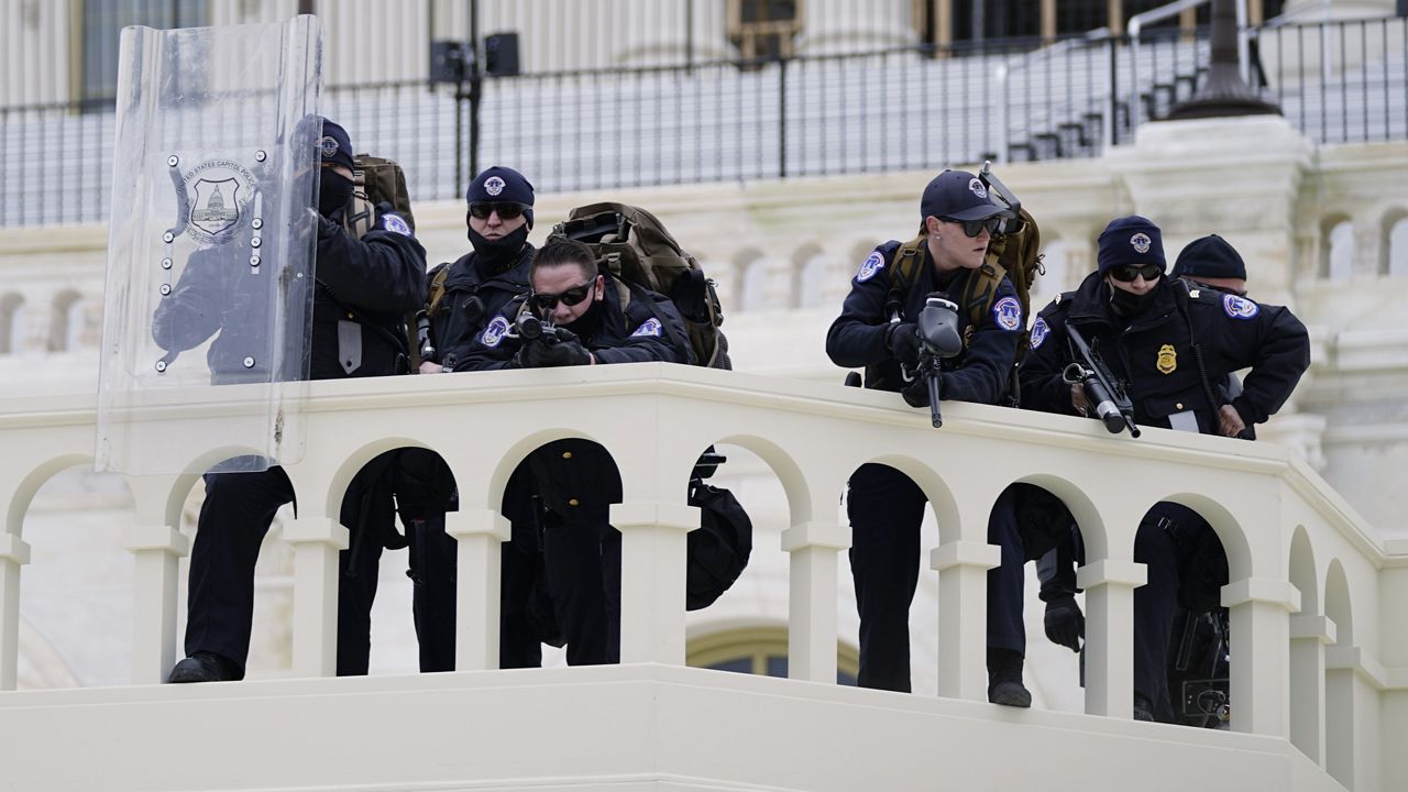 Police keep a watch on demonstrators who tried to break through a police barrier, Wednesday, Jan. 6, 2021, at the Capitol in Washington. (AP Photo/Julio Cortez)