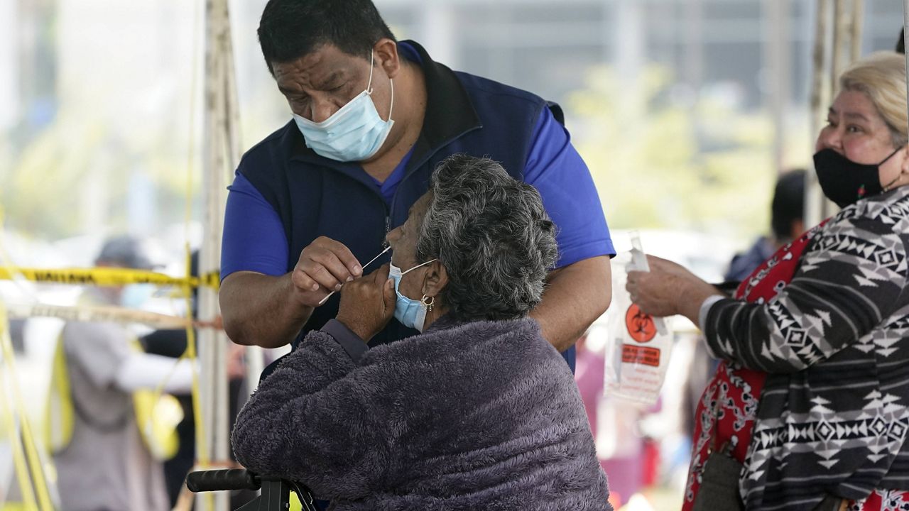 An older woman is aided in taking a COVID-19 test on the Martin Luther King Jr. Medical Campus, Thursday, Jan. 7, 2021, in Los Angeles. (AP Photo/Marcio Jose Sanchez)