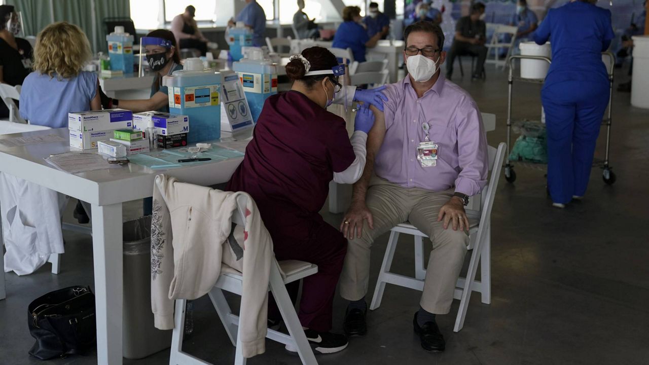 Dr. Michael Forino, right, gets the Pfizer-BioNTech COVID-19 vaccine at St. Joseph Hospital in Orange, Calif., Thursday, Jan. 7, 2021. (AP Photo/Jae C. Hong)