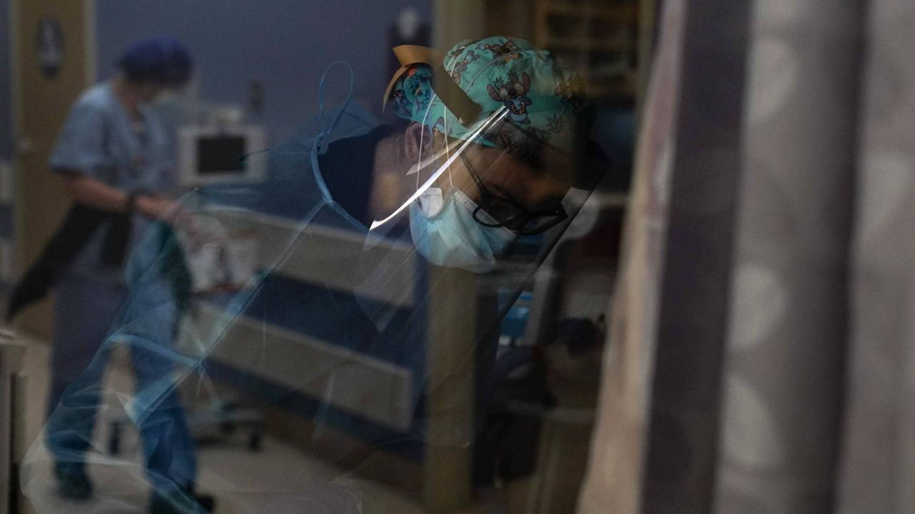 Registered nurse Kyanna Barboza tends to her COVID-19 patient at St. Joseph Hospital in Orange, Calif., Jan. 7, 2021. (AP Photo/Jae C. Hong)