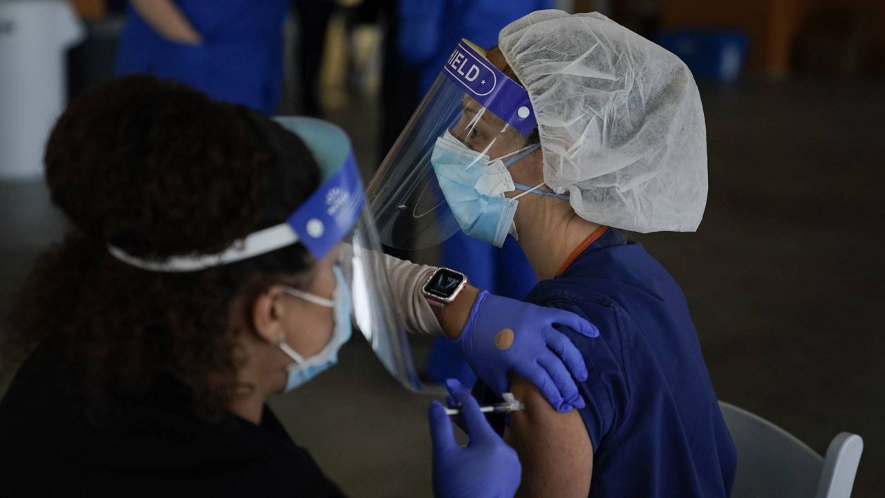 Registered nurse Kimberly Sateri gets the Pfizer-BioNTech COVID-19 vaccine at St. Joseph Hospital in Orange, Calif. Thursday, Jan. 7, 2021. (AP Photo/Jae C. Hong)