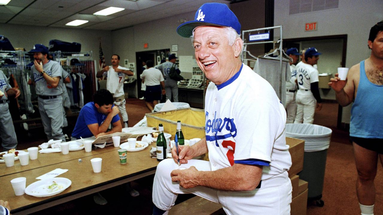 Los Angeles Dodgers manager Tommy Lasorda autographs a baseball in the Dodgertown locker-room in Vero Beach, Fla., in this Feb. 15, 1990 file photo. (AP Photo/Richard Drew)
