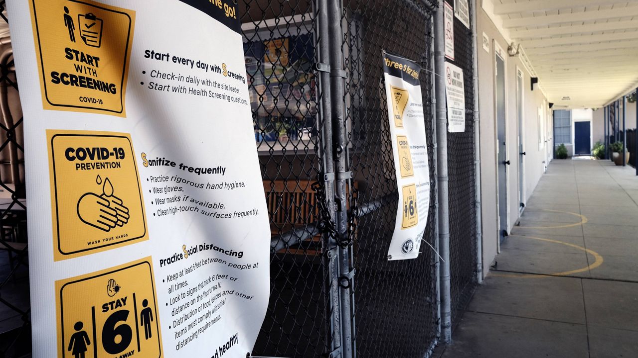In this July 13, 2020, file photo, a gate on a chain-linked fence is locked at the closed Ranchito Elementary School in the San Fernando Valley section of Los Angeles. (AP Photo/Richard Vogel, File)