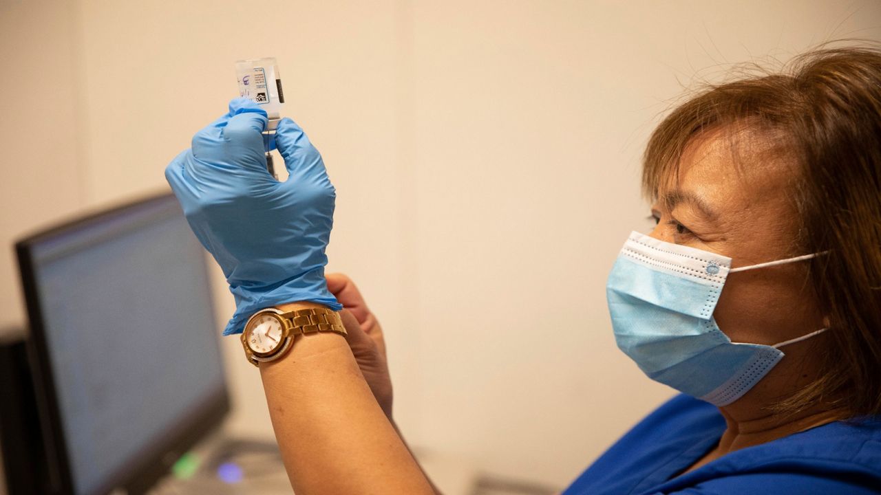Nurse Ellen Quinones prepares a dose of the Moderna COVID-19 vaccine at the Bathgate Post Office vaccination facility on Sunday, Jan. 10, 2021, in the Bronx, New York.