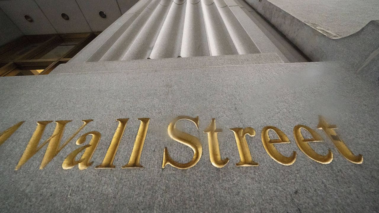 In this Nov. 5, 2020 file photo, a sign for Wall Street is carved in the side of a building. (AP Photo/Mark Lennihan, File)