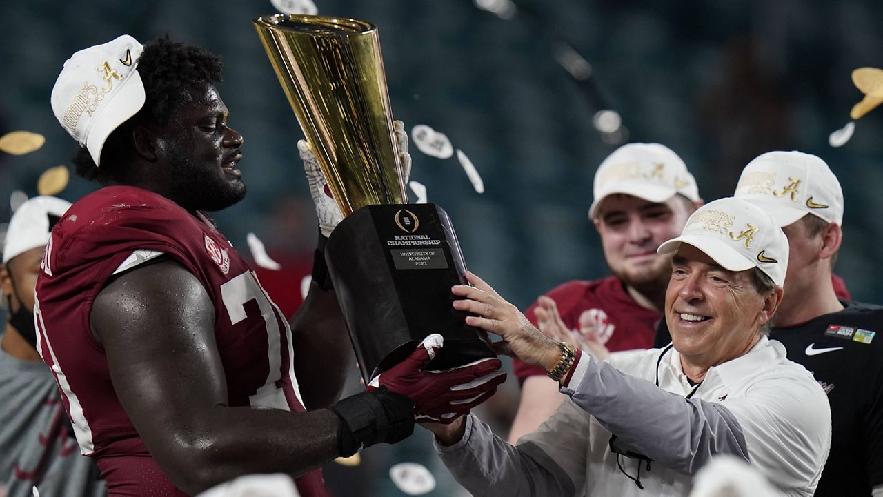 Alabama coach Nick Saban and offensive lineman Alex Leatherwood hold the trophy after their win against Ohio State in the College Football Playoff national championship game. (AP Photo/Chris O'Meara)