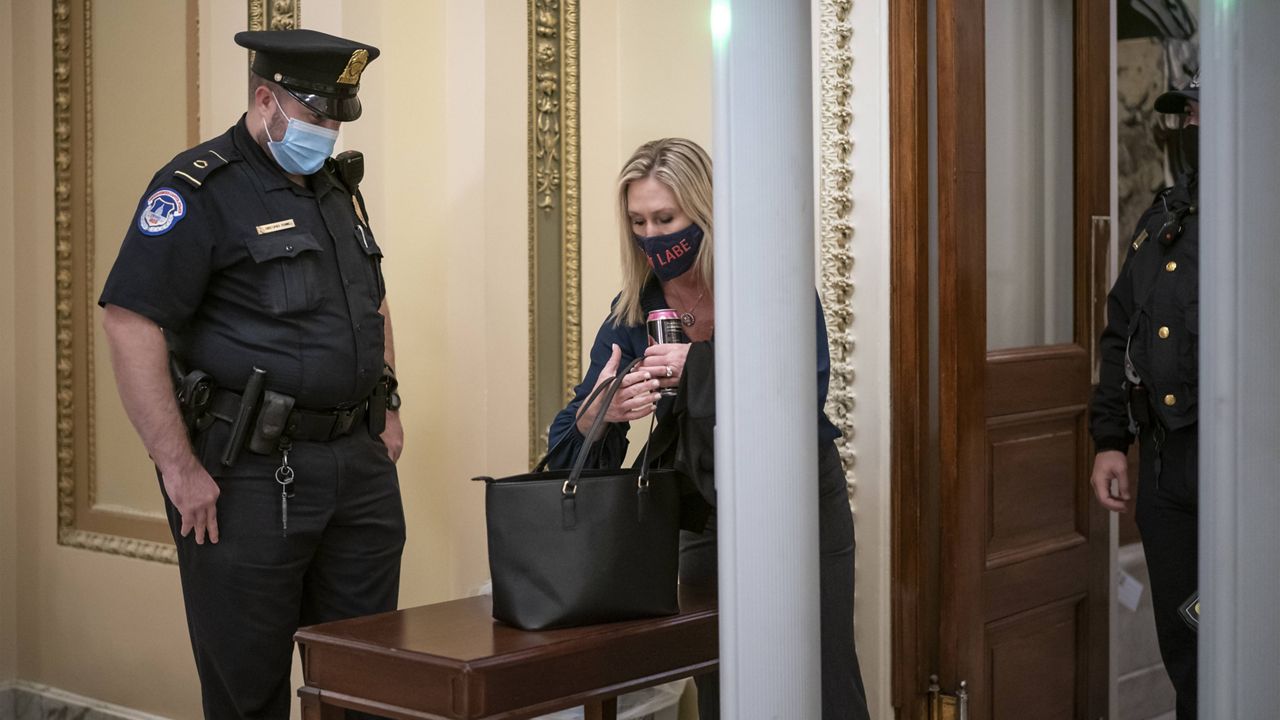 Rep. Marjorie Taylor Greene passes through a metal detector before entering the House chamber on Jan. 12. (AP Photo/J. Scott Applewhite)
