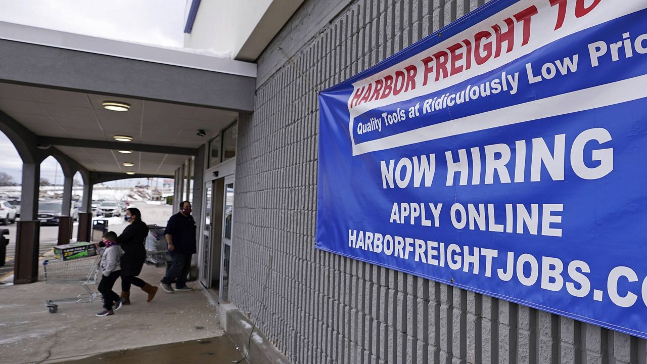 In this Dec. 10, 2020, file photo, a "Now Hiring" sign hangs on the front wall of a Harbor Freight Tools store in Manchester, N.H. (AP Photo/Charles Krupa, File)