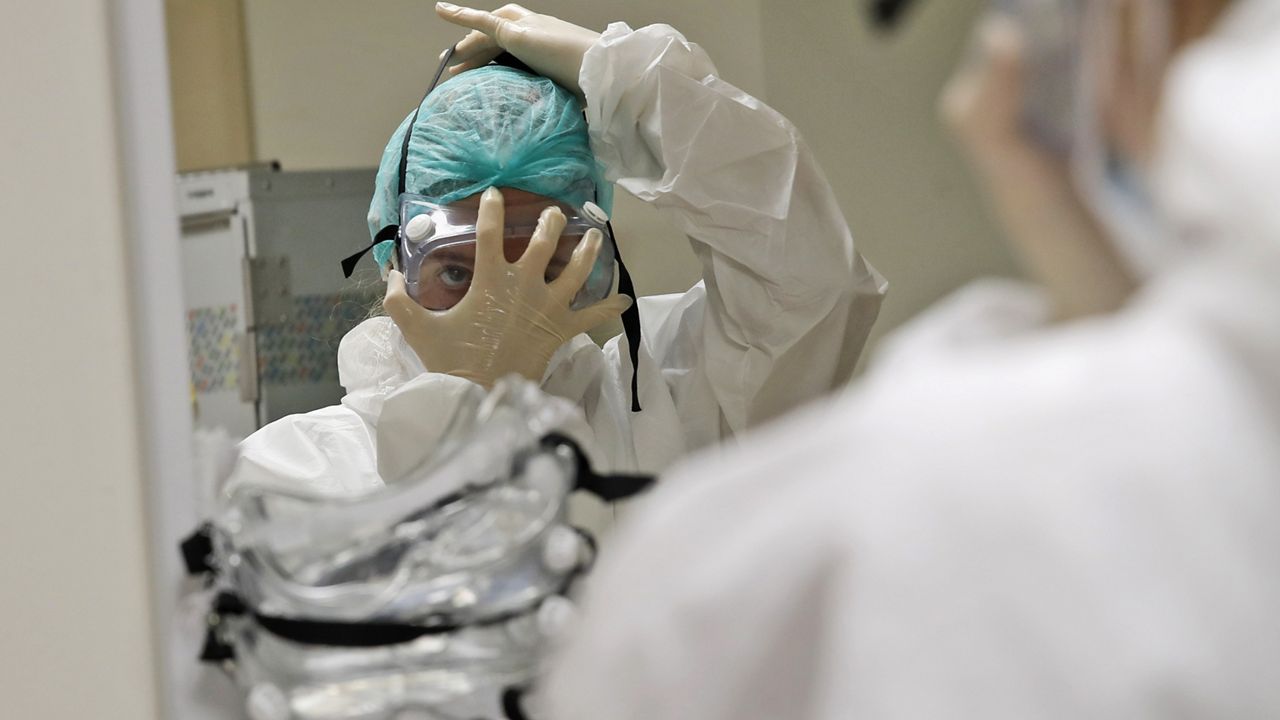 Nurse Ginevra Fattori gets ready before entering the sub-intensive care unit of the San Filippo Neri hospital in Rome, Thursday, Oct. 29, 2020. The global death toll from COVID-19 has topped 2 million. (AP Photo/Alessandra Tarantino)