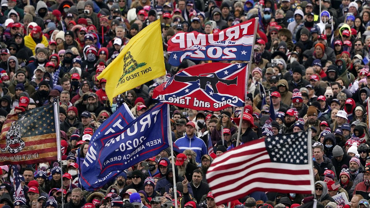 In this Jan. 6 file photo, supporters of President Donald Trump hold Confederate-themed and other flags flutter in Washington, D.C. (AP Photo/Evan Vucci, File)