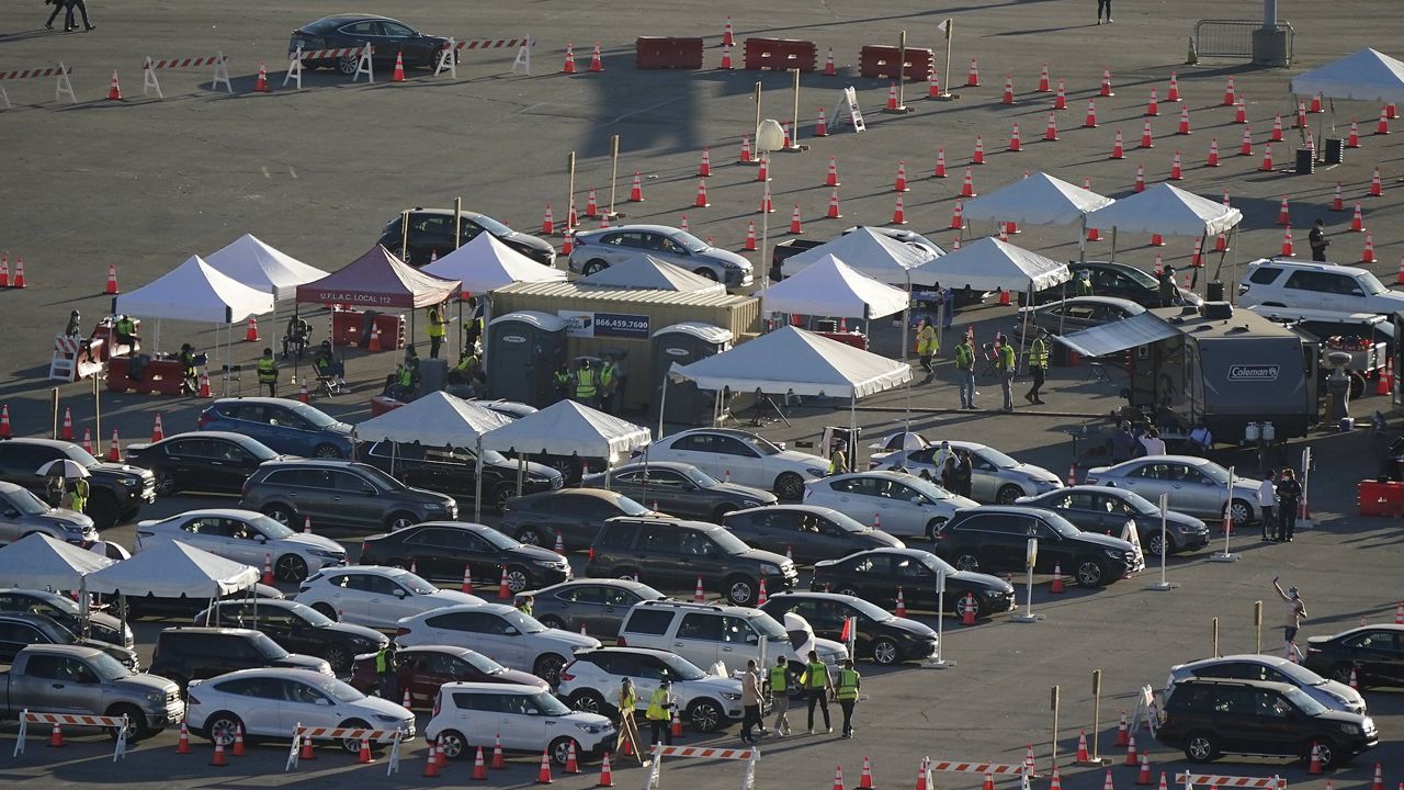 Motorists line up at a COVID-19 vaccination site at Dodger Stadium Friday, Jan. 15, 2021, in Los Angeles. (AP Photo/Marcio Jose Sanchez)