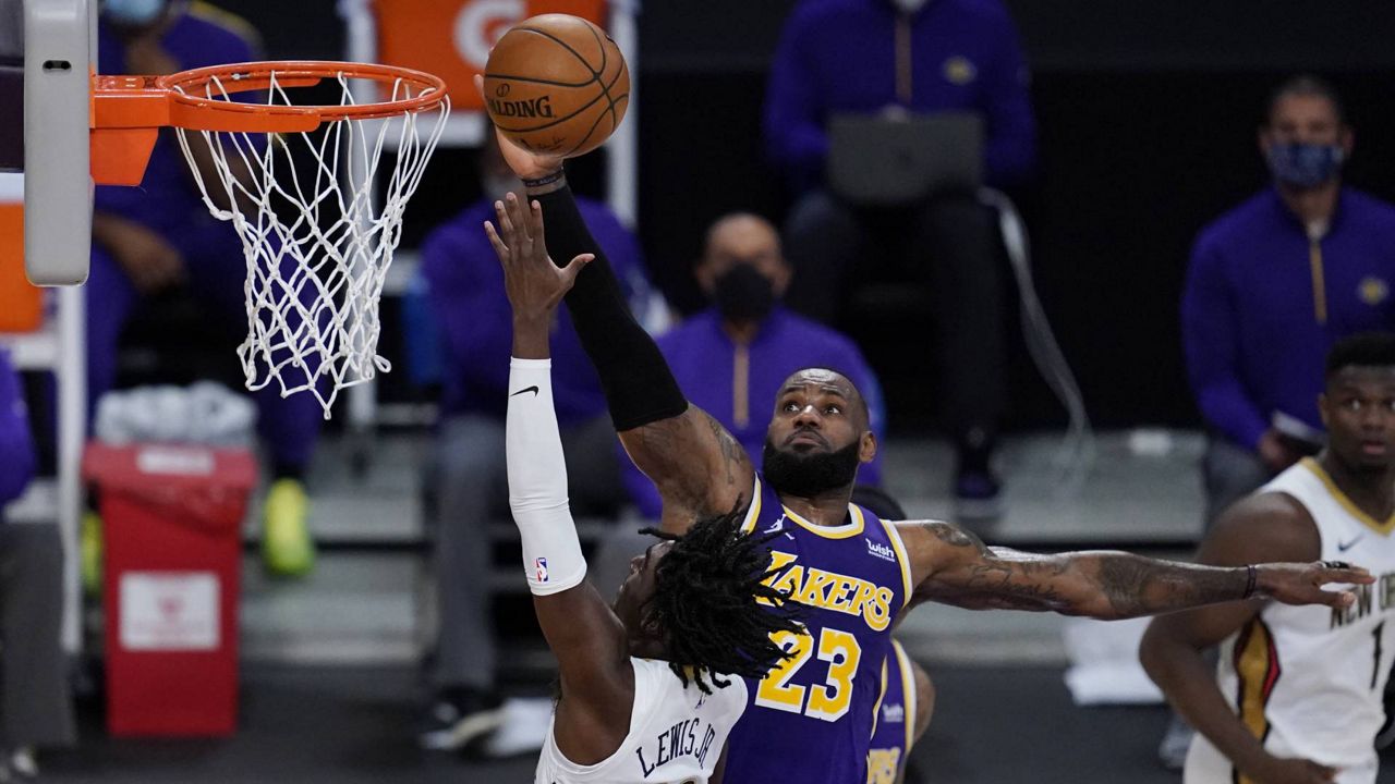 LeBron James defends against New Orleans Pelicans guard Kira Lewis Jr. (13) during an NBA game Friday, Jan. 15, 2021, in Los Angeles. (AP/Ashley Landis)