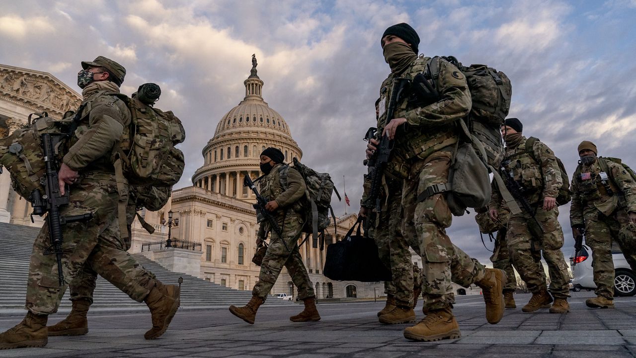 Armed National Guard troops walk past the U.S. Capitol two days before the 59th Presidential Inauguration in Washington, Monday, Jan. 18, 2021. (AP Photo/Andrew Harnik)