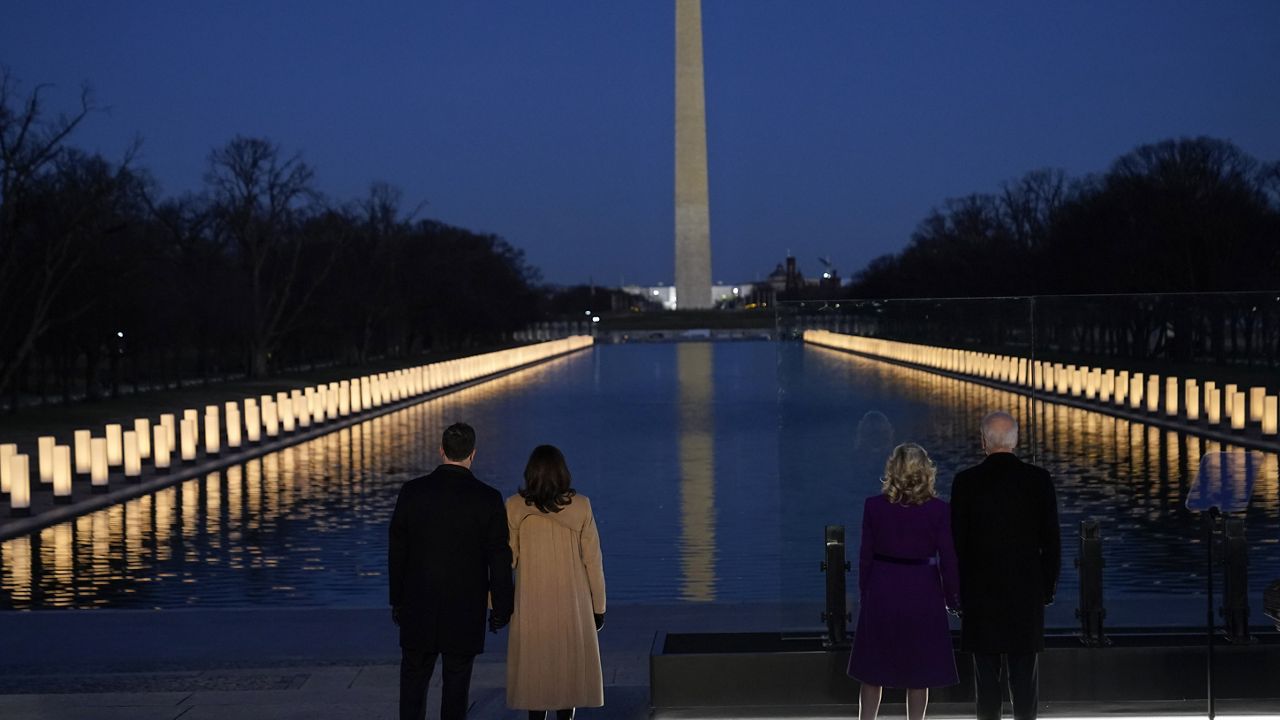 President-elect Joe Biden and his wife Jill, along with Vice President-elect Kamala Harris and her husband Doug Emhoff stand during a COVID-19 memorial, and look at lights placed around the Lincoln Memorial Reflecting Pool, Tuesday, Jan. 19, 2021, in Washington. (AP Photo/Alex Brandon)