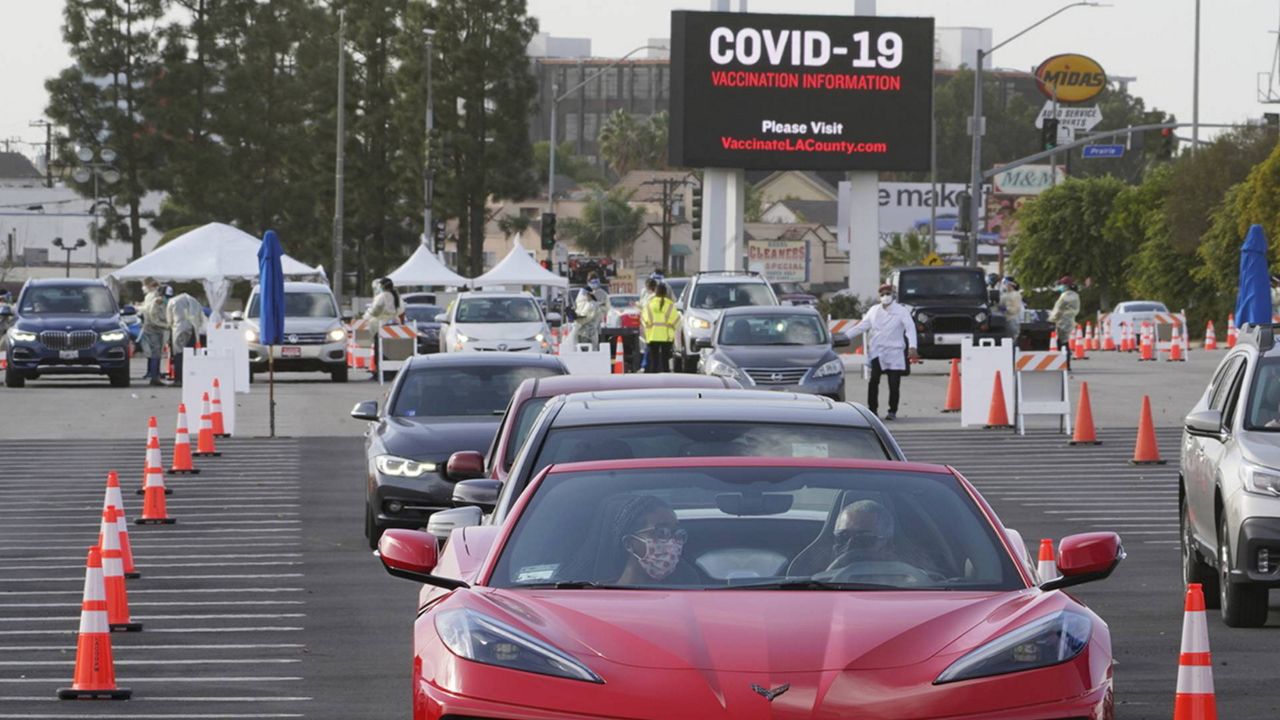 People wait in their vehicles to monitor for adverse reactions to the shot, after being vaccinated at a mass COVID-19 vaccination site outside The Forum in Inglewood, Calif., Tuesday, Jan. 19, 2021. (AP/Damian Dovarganes)