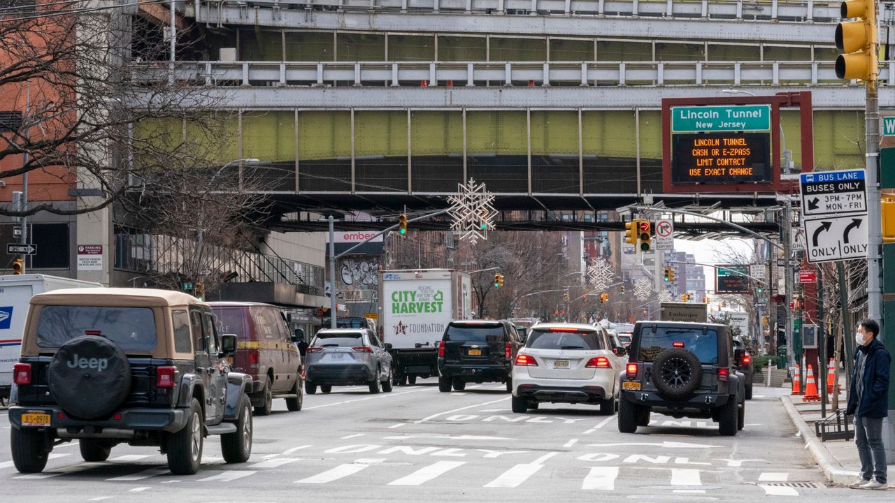 Traffic makes its way down 9th Avenue as a bus is seen on a ramp overhead leaving the Port Authority Bus Terminal, Friday, Jan. 22, 2021, in New York.