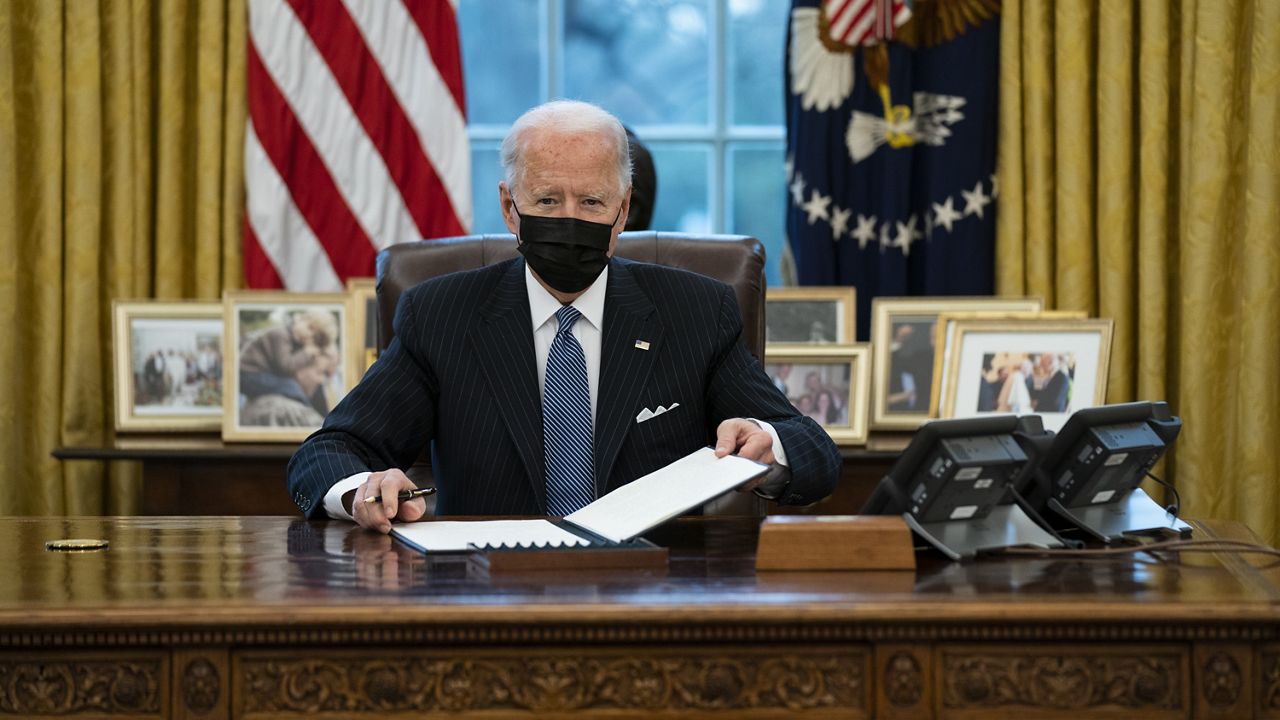 President Joe Biden looks up after singing an Executive Order reversing the Trump era ban on Transgender serving in military, in the Oval Office of the White House, Monday, Jan. 25, 2021, in Washington. (AP Photo/Evan Vucci)