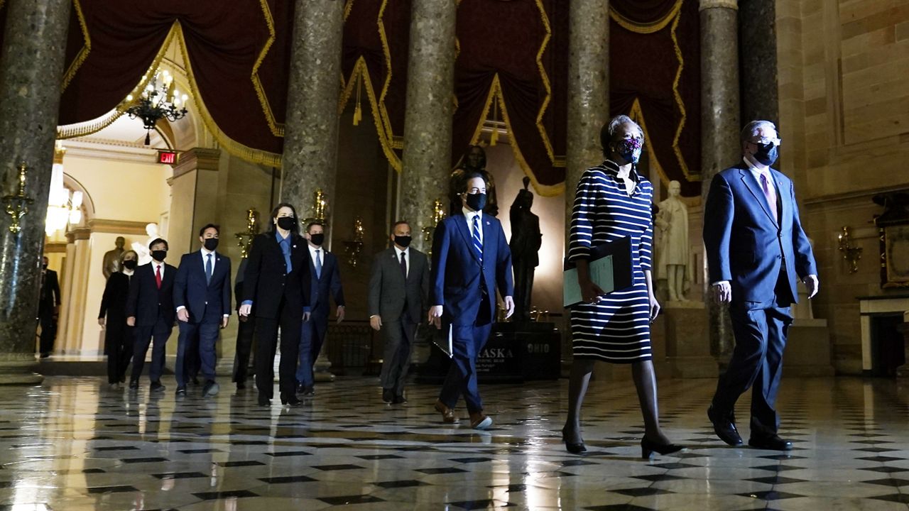 Clerk of the House Cheryl Johnson along with acting House Sergeant-at-Arms Tim Blodgett, lead the Democratic House impeachment managers as they walk through Statuary Hall in the Capitol, to deliver to the Senate the article of impeachment alleging incitement of insurrection against former President Donald Trump, Monday, Jan. 25, 2021 in Washington. (AP Photo/Susan Walsh)