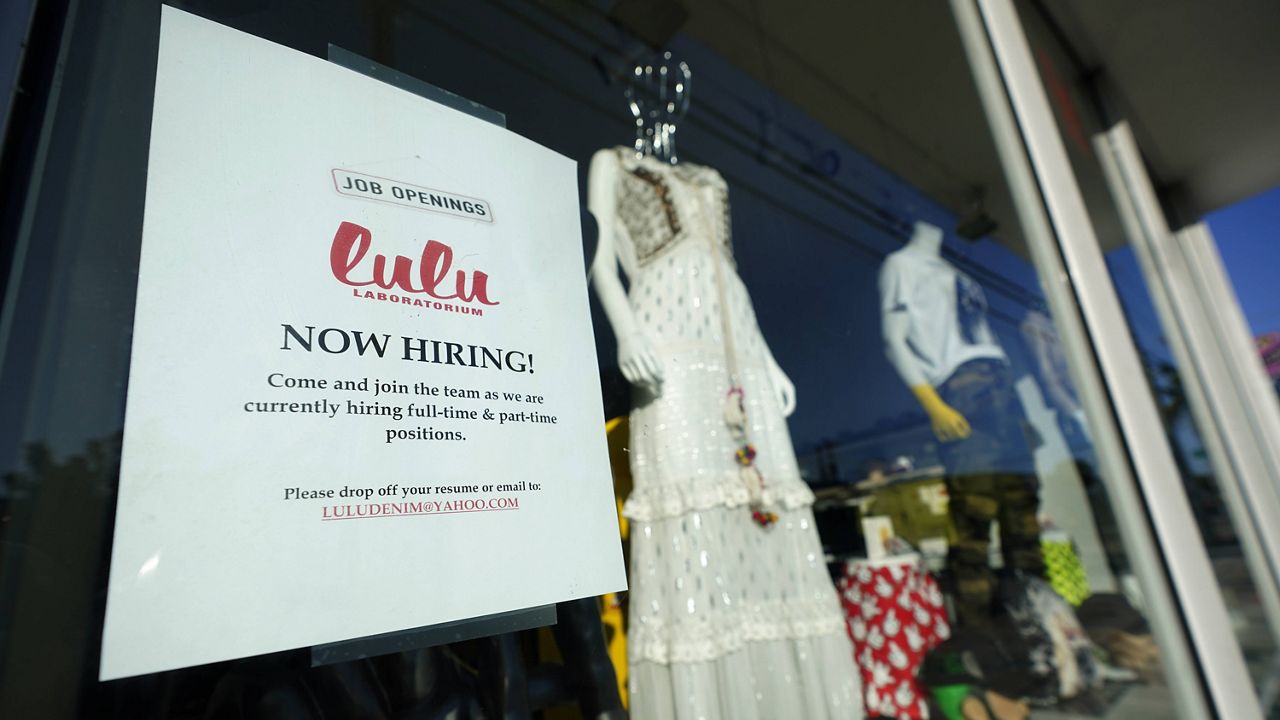 A "Now Hiring" sign is shown in the window of a store in the Wynwood Arts District of Miami on Wednesday. (AP Photo/Wilfredo Lee)