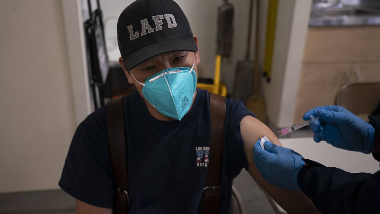 Firefighter Henry Hsieh receives his second dose of the COVID-19 vaccine at a fire station in Los Angeles, Wednesday, Jan. 27, 2021. (AP Photo/Jae C. Hong)