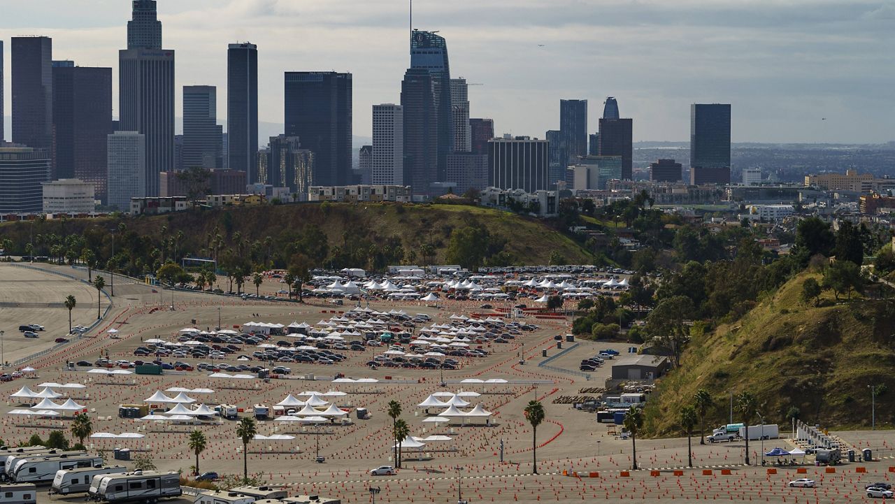 In this Jan. 27, 2021 file photo, drivers wait in line at a mega COVID-19 vaccination site set up in the parking lot of Dodger Stadium in Los Angeles. (AP Photo/Damian Dovarganes)