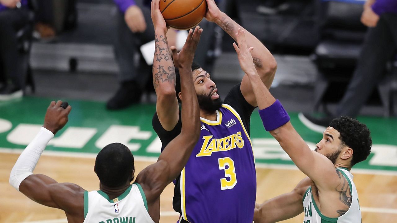 Los Angeles Lakers' Anthony Davis (3) shoots between Boston Celtics' Jaylen Brown (7) and Jayson Tatum during the first half of an NBA basketball game Saturday, Jan. 30, 2021, in Boston. (AP Photo/Michael Dwyer)