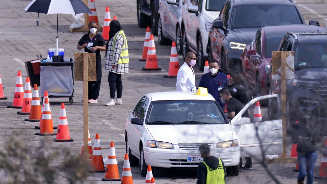 Medical workers administer vaccinations at the Dodger Stadium parking lot to receive the COVID-19 vaccine Monday, Feb. 1, 2021, in Los Angeles. (AP Photo/Mark J. Terrill)