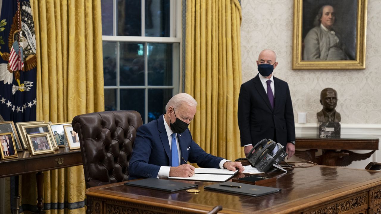 Secretary of Homeland Security Alejandro Mayorkas looks on as President Joe Biden signs an executive order on immigration, in the Oval Office of the White House, Tuesday, Feb. 2, 2021, in Washington. (AP Photo/Evan Vucci)