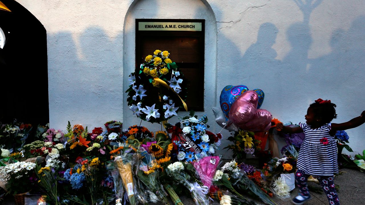 FILE - In this June 18, 2015, file photo, mourners pass by a makeshift memorial on the sidewalk in front of the Mother Emanuel AME Church following the shooting of nine Black parishioners in Charleston, S.C. (AP Photo/Stephen B. Morton, File)